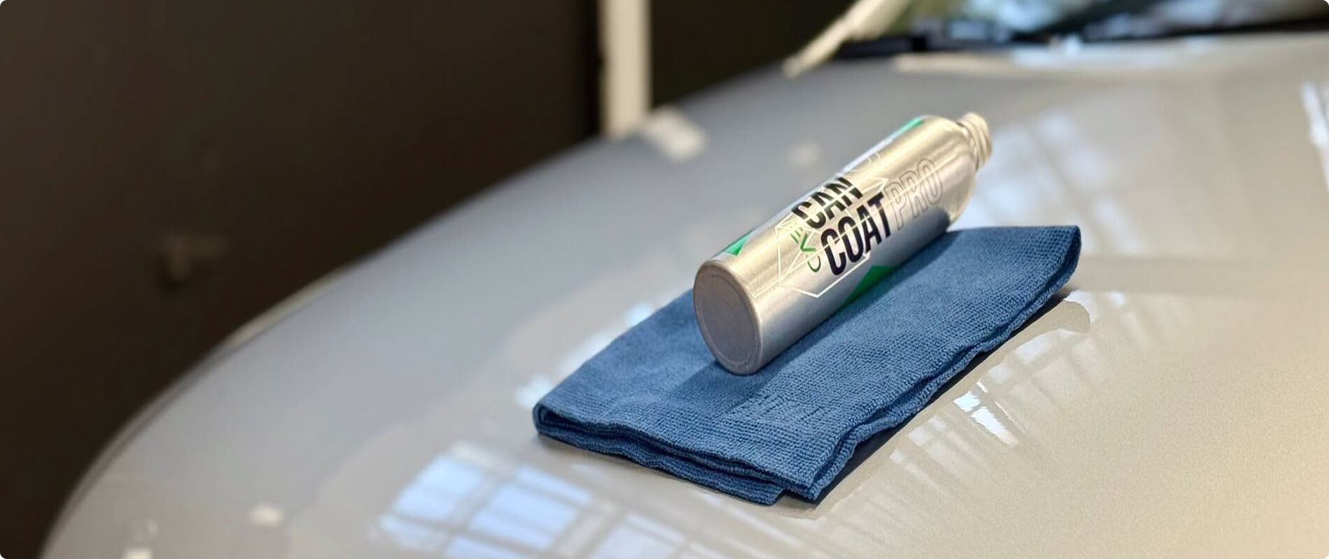 Prodotto per la cura dell’auto su un panno in microfibra appoggiato alla carrozzeria.