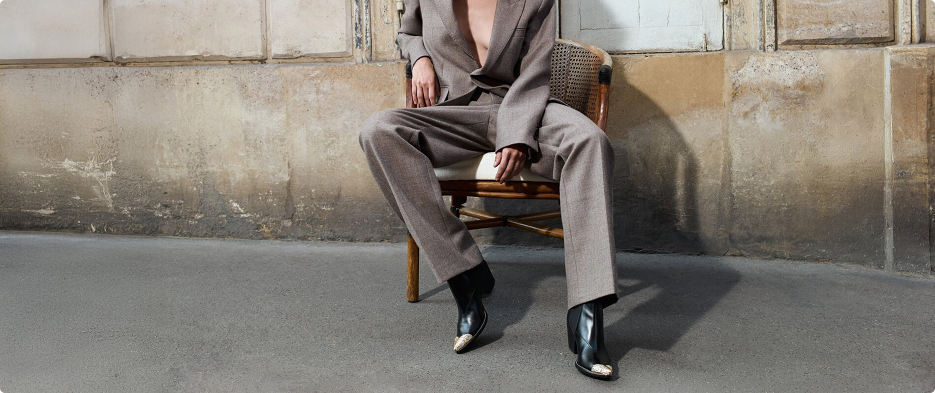Modello seduto con abito e calzature Giuseppe Zanotti.